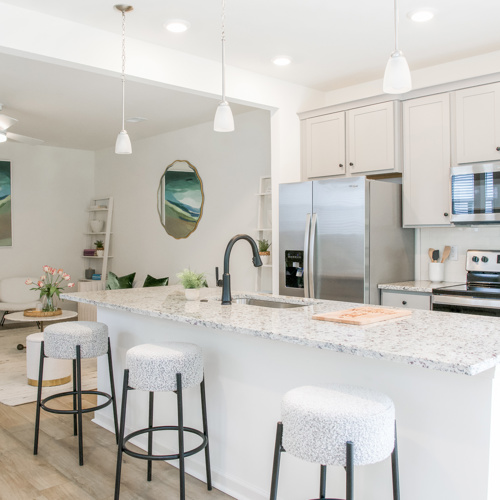 Kitchen with an island and three bar stools at Harmon Foxbank townhomes in Moncks Corner