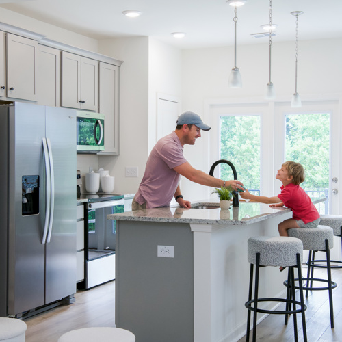 Kitchen with an island and three bar stools at Harmon Foxbank townhomes in Moncks Corner