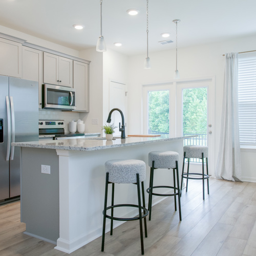 Kitchen with an island and three bar stools at Harmon Foxbank townhomes in Moncks Corner